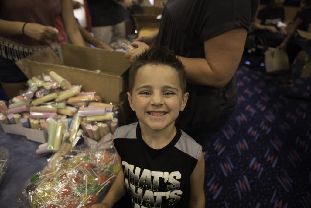 A child in front of a community assembly line to create 'treasure boxes' for victims of domestic abuse