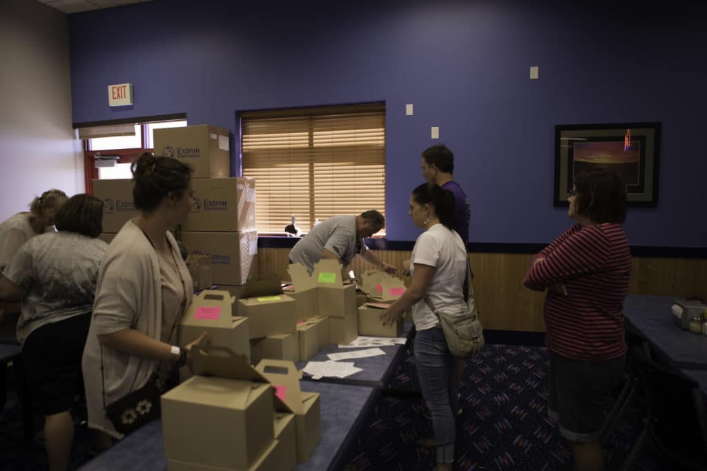 Marshall Industries employees at a community project assembly line putting treasure boxes together for kids